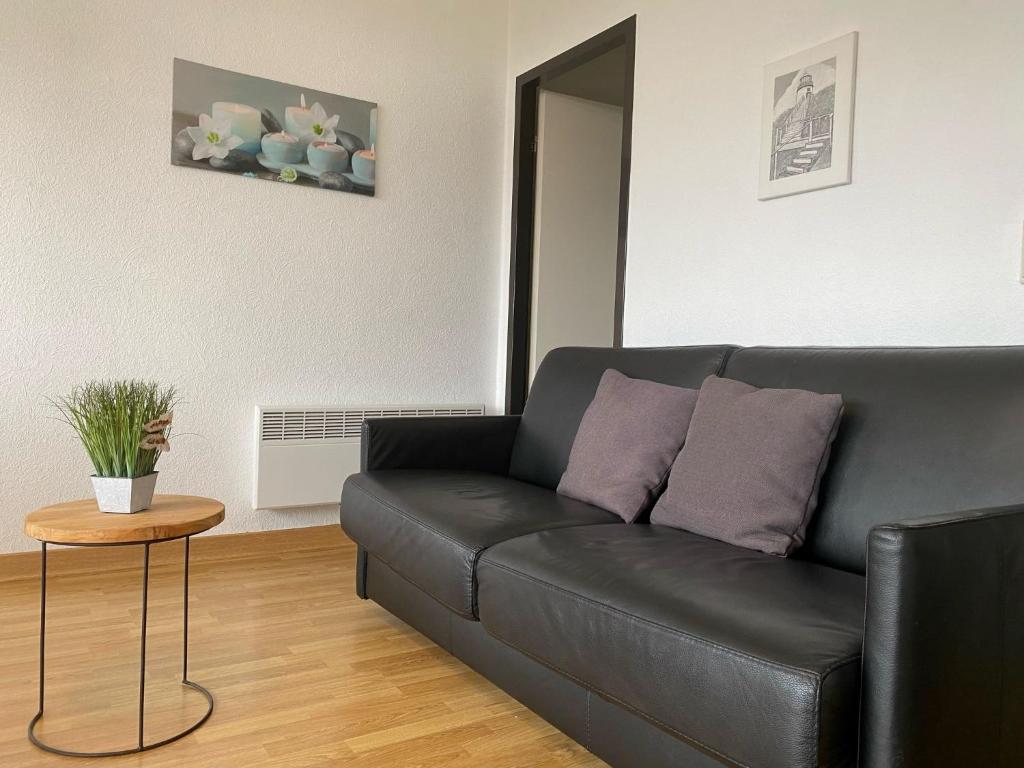 un sofá de cuero negro en una sala de estar con mesa en Apartment Residentie Astrid-1 by Interhome, en Bredene