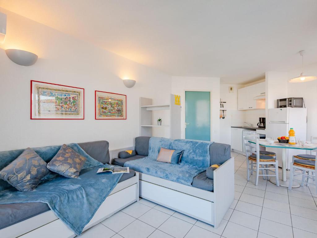 sala de estar con sofás azules y cocina en Apartment L'Open-12 by Interhome, en Fréjus