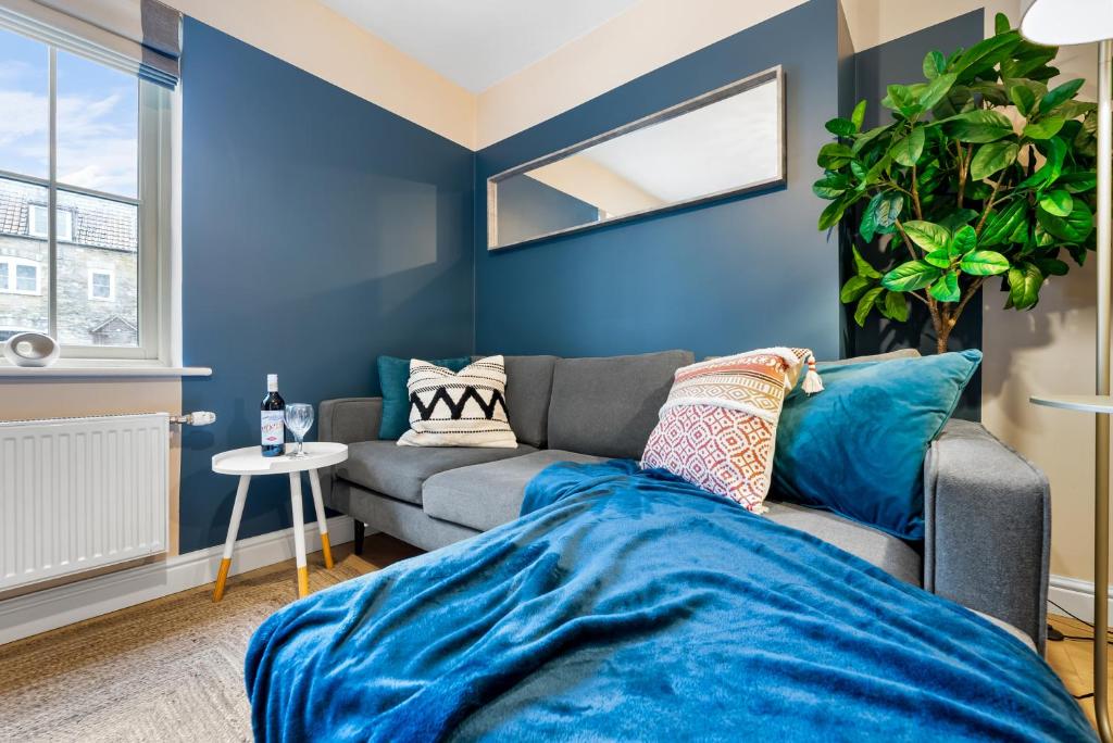 een woonkamer met blauwe muren en een bank bij 2 bedroom apartment in the Town centre with free private parking in Cirencester