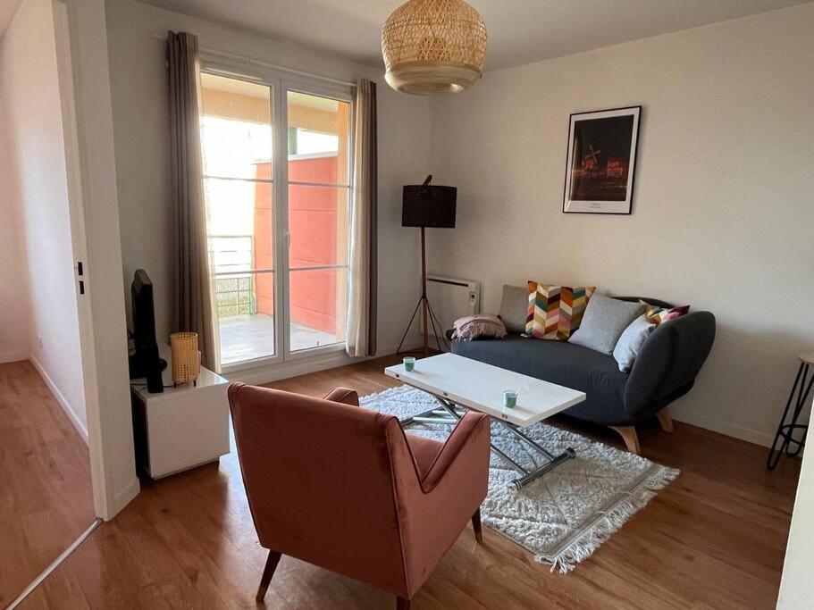 sala de estar con sofá y mesa en Appartement 2 pièces Bois d’Arcy en Bois-dʼArcy