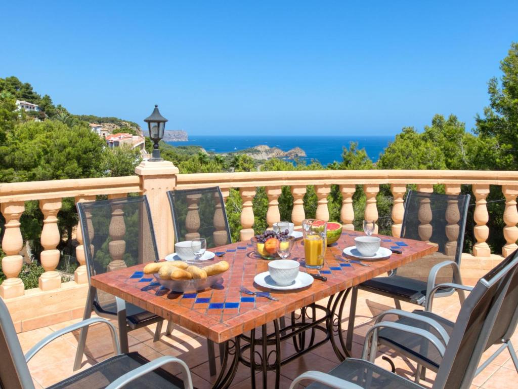 una mesa de madera con comida en el balcón en Villa Villa Bellevue by Interhome, en Jávea