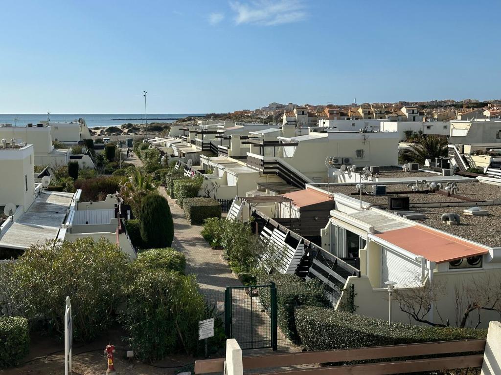 Une rangée de maisons avec l'océan en arrière-plan dans l'établissement Village naturiste - Villa Port-Nature 1 - Le Tantra, au Cap d'Agde