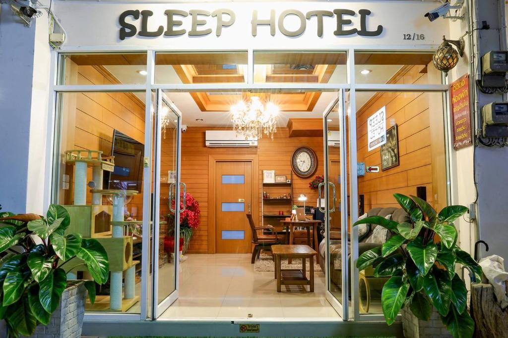 uma porta de vidro deslizante de um hotel para dormir com uma mesa em Sleep Hotel em Chon Buri