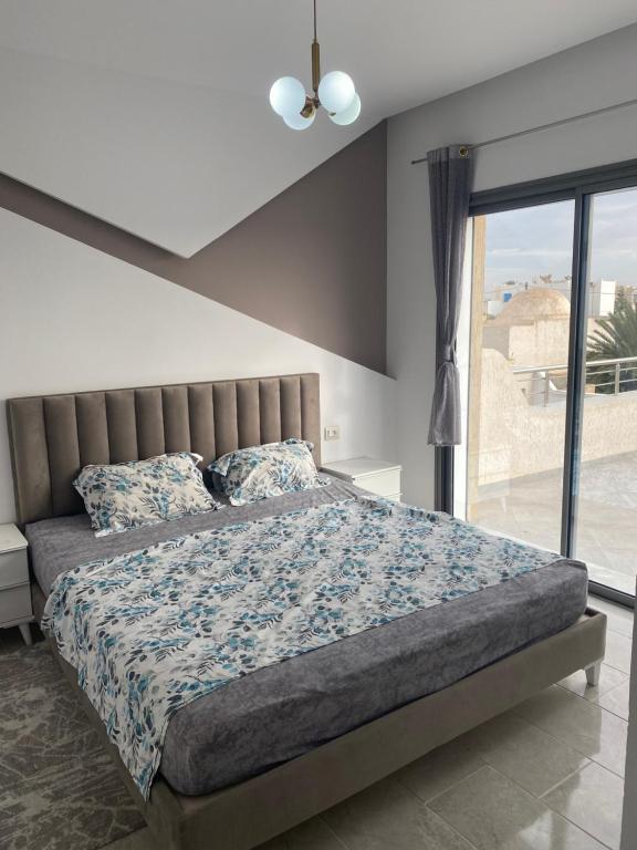 a bedroom with a large bed with a window at Villa oasis in Houmt Souk
