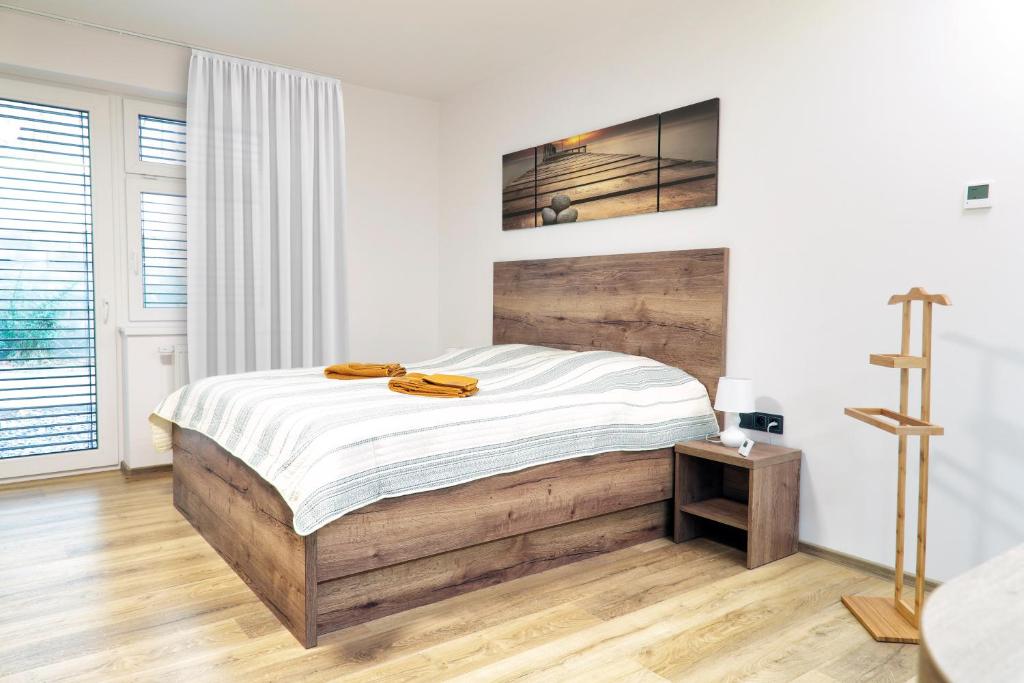 a bedroom with a large bed with a wooden headboard at Lanškroun apartmány v centru in Lanškroun