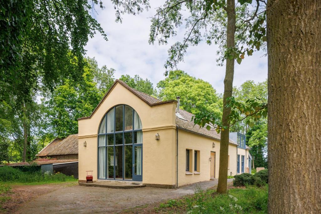 a house with a large window on the side of it at Koetshuis Buitenplaats Iepenoord in Oostkapelle