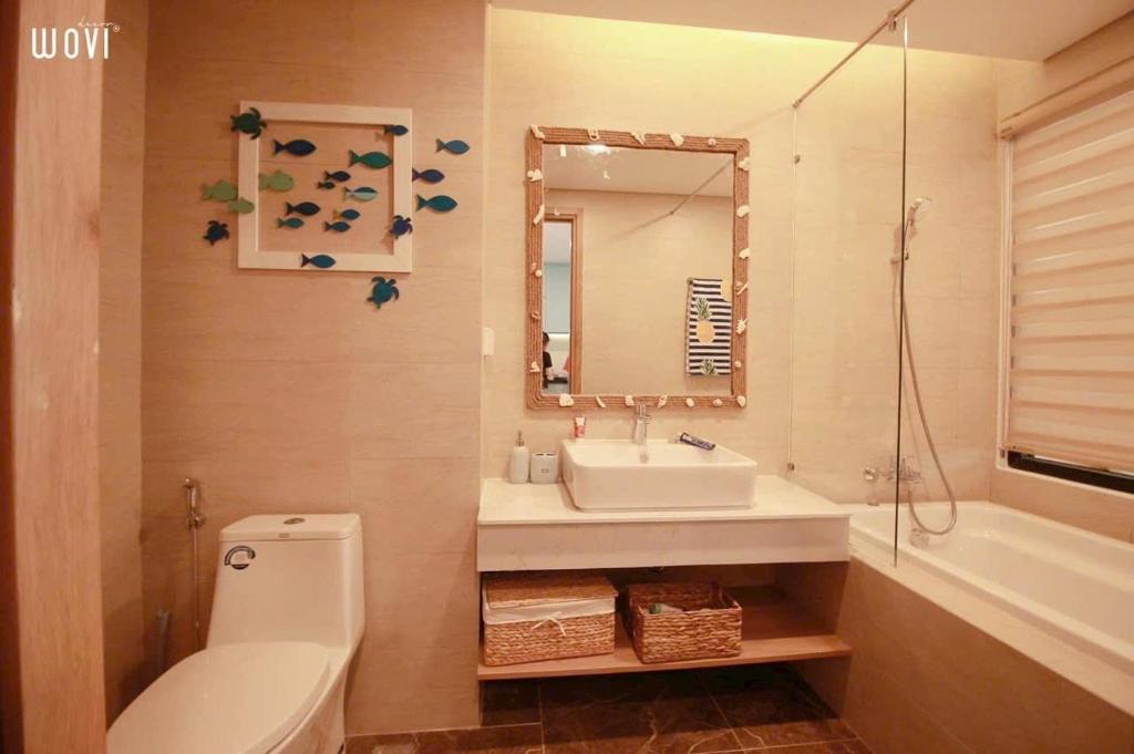 y baño con lavabo, aseo y espejo. en FLC SEATOWN QUY NHƠN, en Quy Nhon