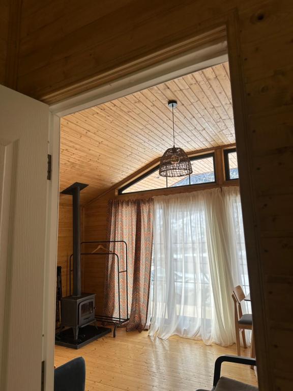 sala de estar con ventana grande y lámpara de araña en Mestia Villas, en Mestia