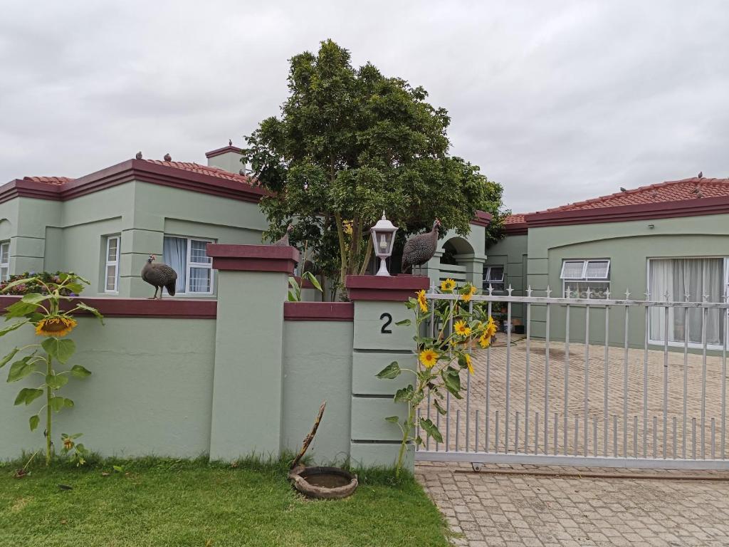 a fence in front of a house with a gate at Wave Echo in Plettenberg Bay