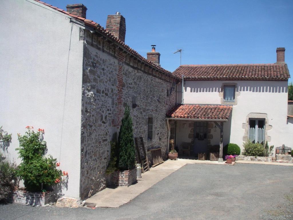 a large stone building with a courtyard in front of it at Chambre d'hôte du Plessis in Beaurepaire