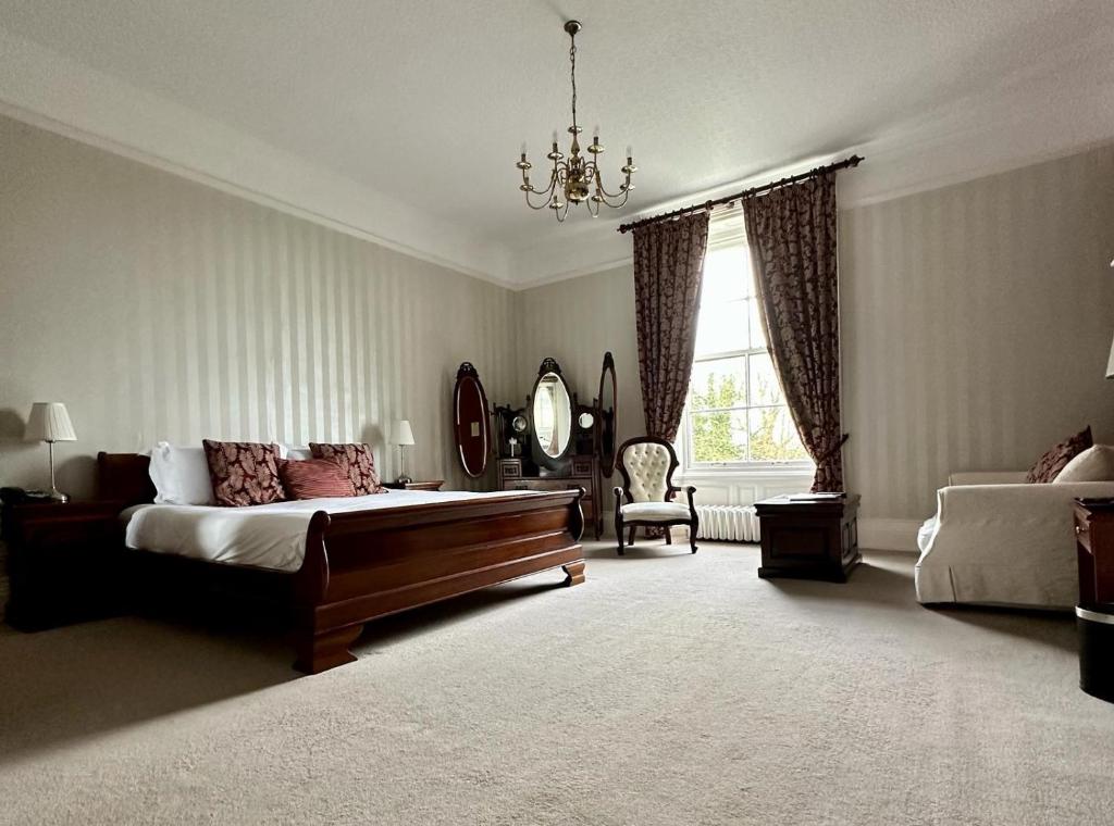 a large bedroom with a bed and a mirror at Solberge Hall in Northallerton
