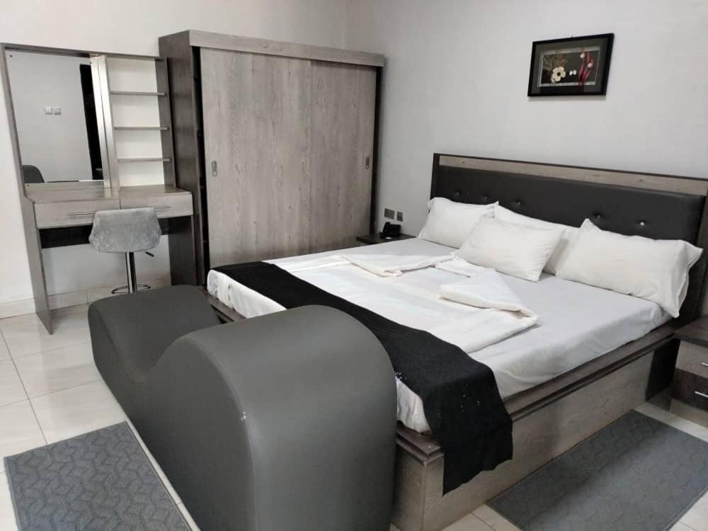 a bedroom with a large bed with a chair at Luckyone Hotel in Lilongwe