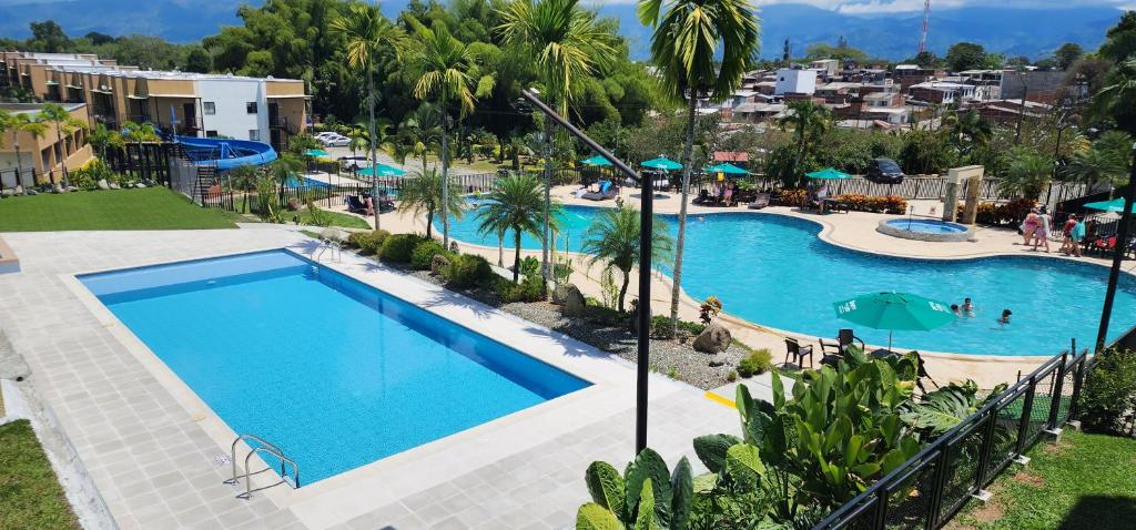 - une vue sur la piscine d'un complexe dans l'établissement Apartamento Nuevo, Eje Cafetero, Rodeado de Naturaleza., à La Tebaida