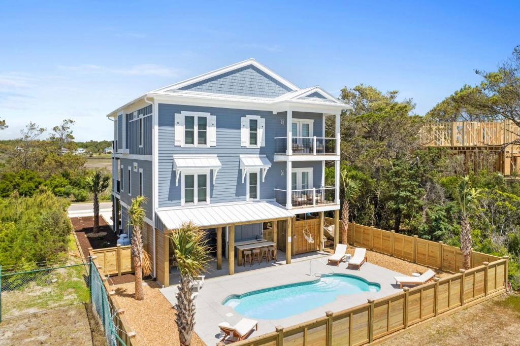 a house with a swimming pool in front of it at Havana in Ocean Isle Beach