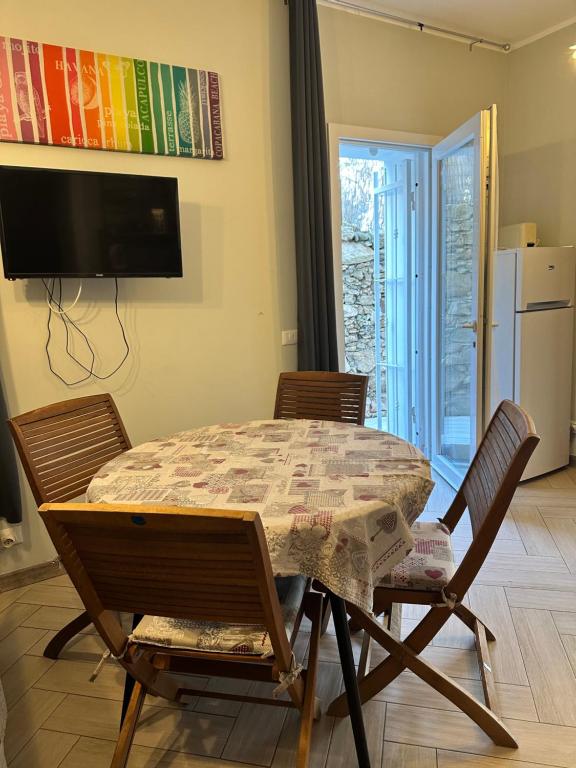a dining room table with two chairs and a television at Casa del sasso in Bergeggi