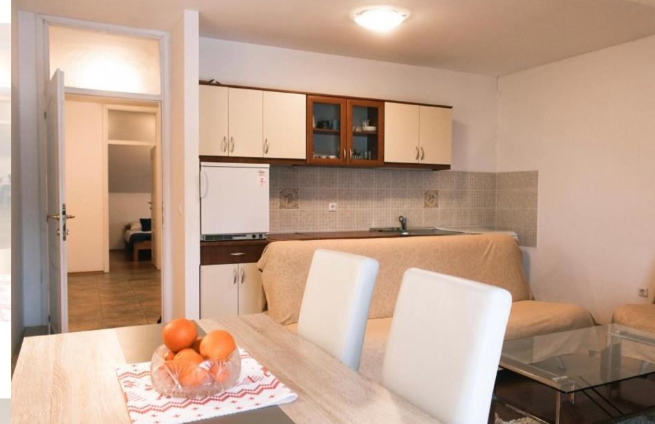 a kitchen and living room with a table and chairs at Apartman Oskar 1 in Kupres