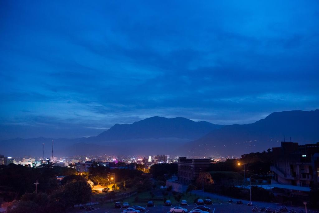a view of a city at night with mountains at Zhileju Homestay in Hualien City