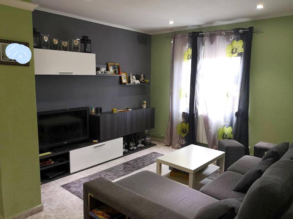 a living room with a couch and a tv at 2 bedrooms apartement with wifi at Barbastro in Barbastro