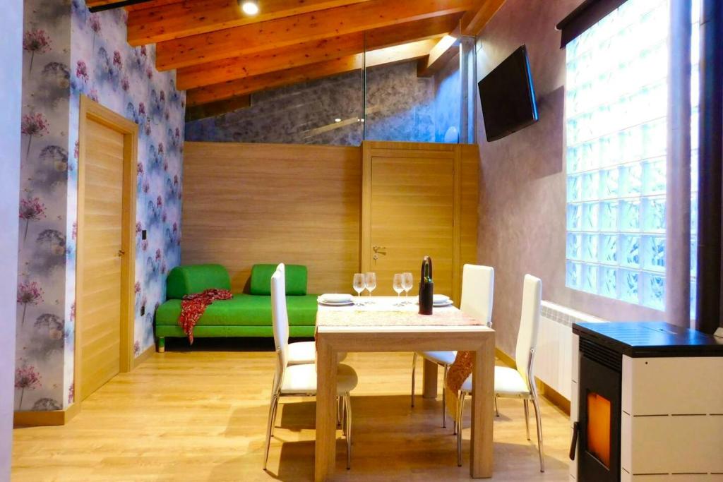 une salle à manger avec une table et un canapé vert dans l'établissement 2 bedrooms appartement with wifi at Tubilla del Lago, à Tubilla del Lago