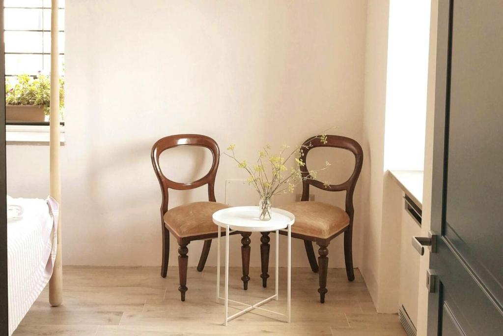 twee stoelen en een tafel met een vaas erop bij 2 bedrooms appartement with terrace at Finocchito in Finocchito