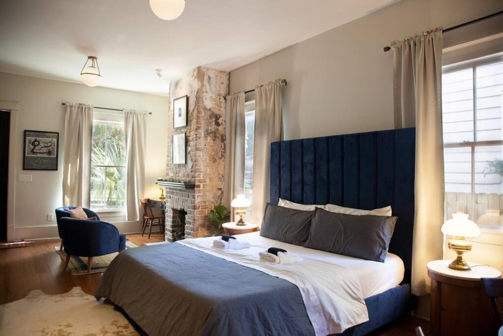 une chambre avec un grand lit et une tête de lit bleue dans l'établissement Intimate Library Studio - Minutes to Forsyth Park, à Savannah