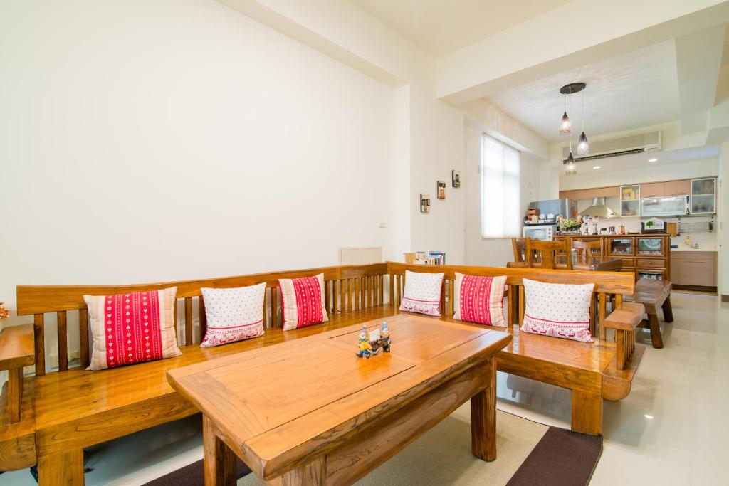 a dining room with wooden tables and red and white pillows at Zhileju Homestay in Hualien City