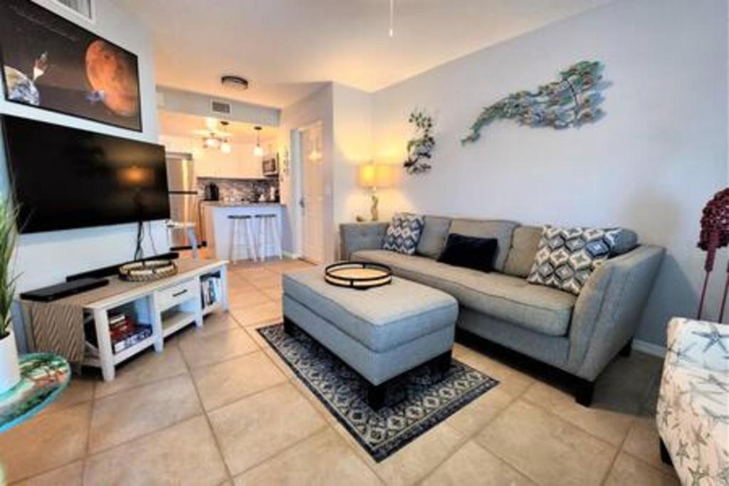 een woonkamer met een bank en een flatscreen-tv bij Atrium Oceanview Condo - Sleeps 4 Guests 109 in Cape Canaveral