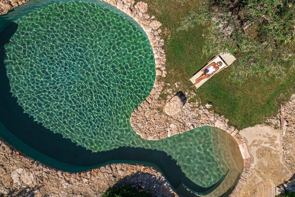 an overhead view of a lake with a person in a house at Masseria Brigantino in Torre Canne