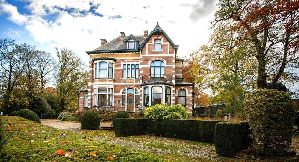 a large red brick house with a turret at Boutique hotel Shamon in Eeklo