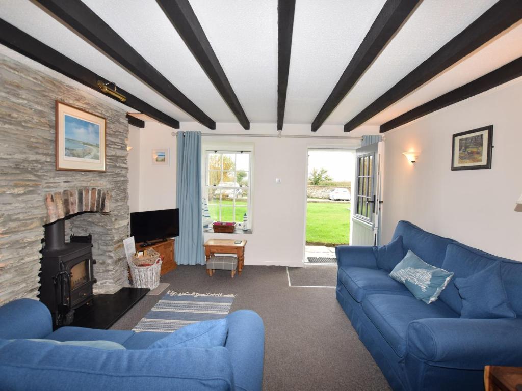 a living room with blue couches and a fireplace at 2 Bed in Padstow KCOTT in Wadebridge