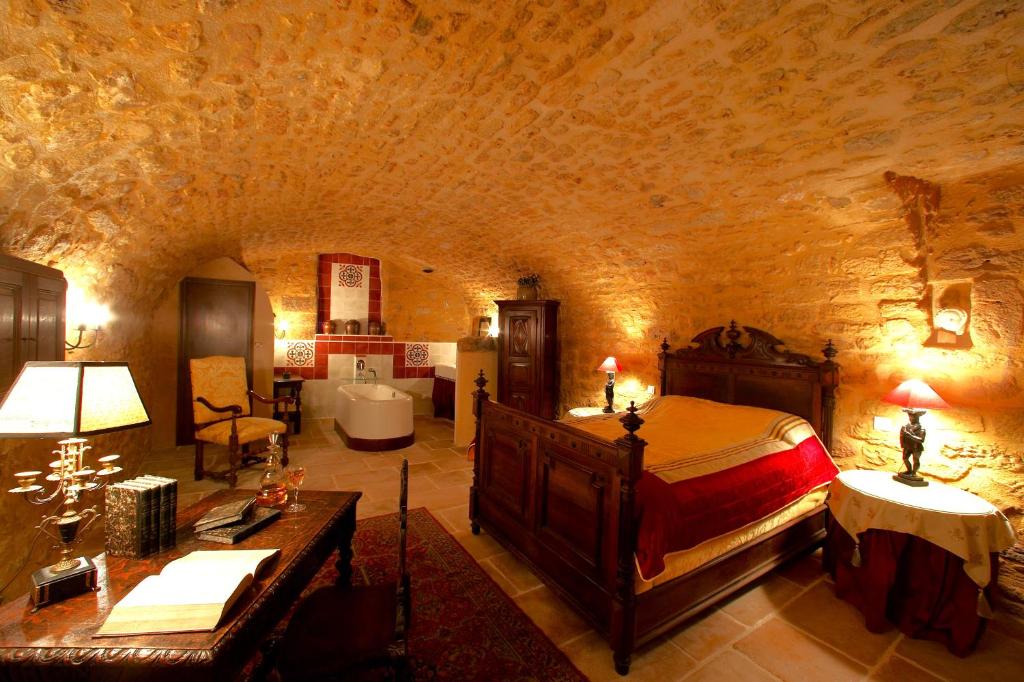 a bedroom with a bed and a couch in a room at Logis Hôtel Le Boudoir in Belvès