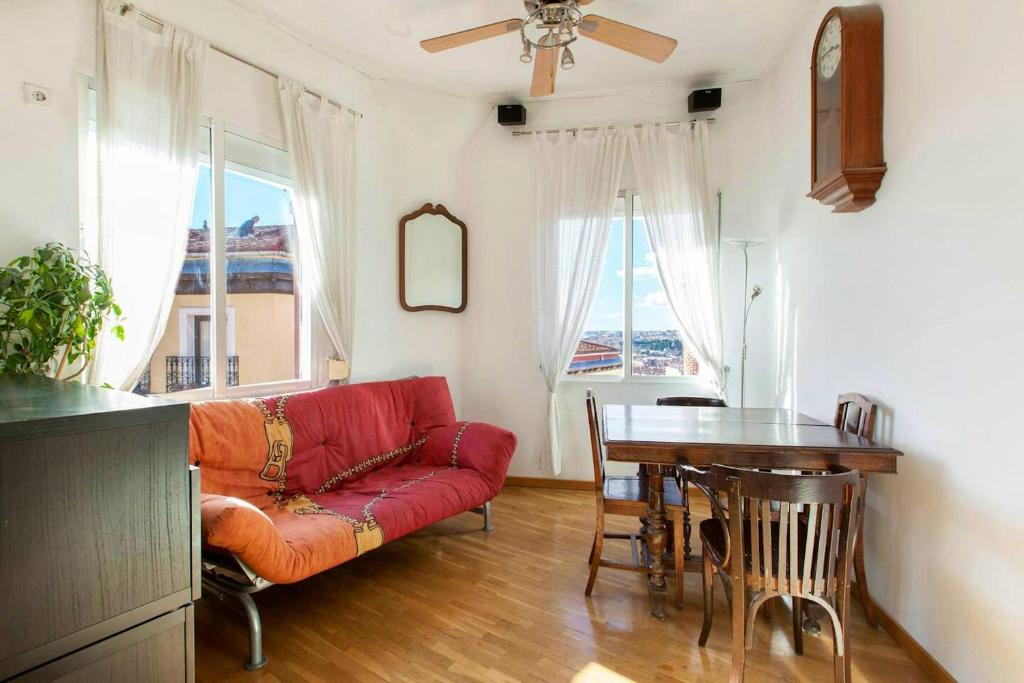 uma sala de estar com um sofá vermelho e uma mesa em 2 bedrooms apartement with wifi at Madrid em Madri