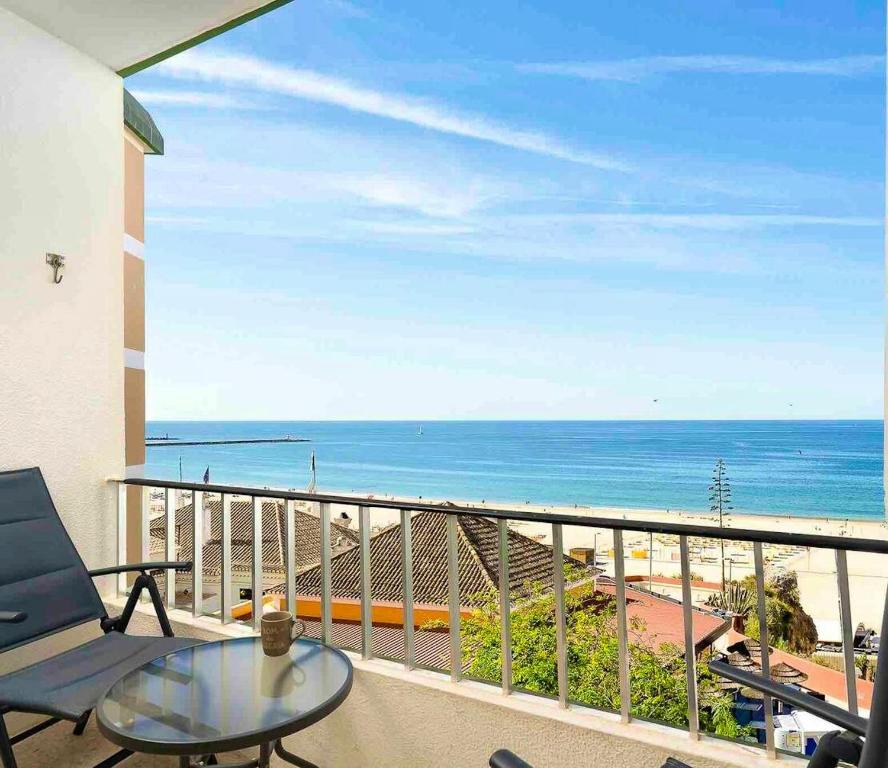 einen Balkon mit einem Tisch und Meerblick in der Unterkunft 2 bedrooms apartement at Portimao 10 m away from the beach with wifi in Portimão
