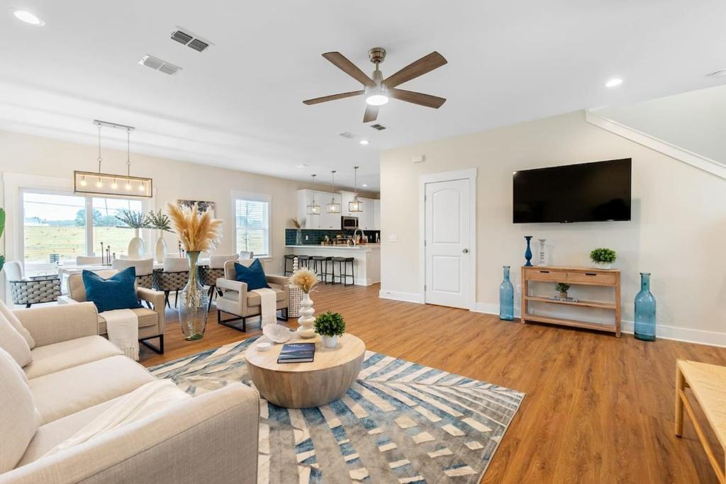 sala de estar con muebles blancos y TV de pantalla plana en Ocean Breeze- Chic Steps to beach Family Friendly, en St. Augustine