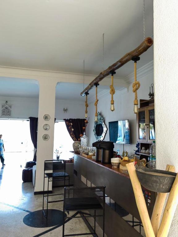 a kitchen and living room with a counter and chairs at Riad Ras Lafaa in Safi