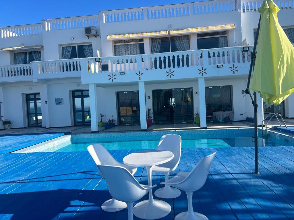 a pool with a table and chairs next to a building at Riad Ras Lafaa in Safi
