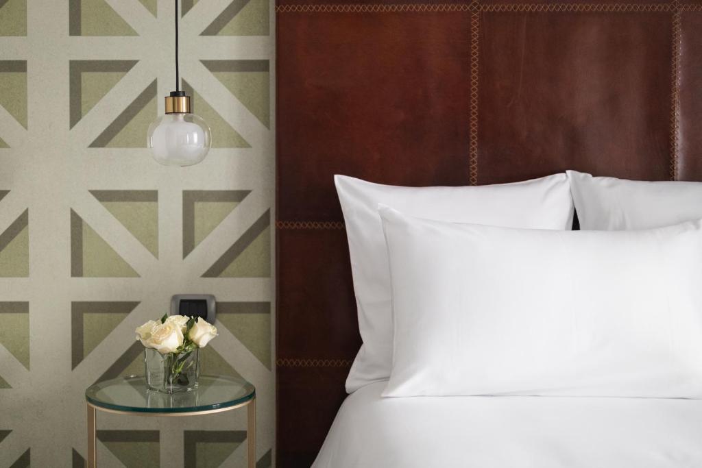 a bedroom with a bed and a table with a vase of flowers at Maison Roma Piazza di Spagna UNA Esperienze in Rome