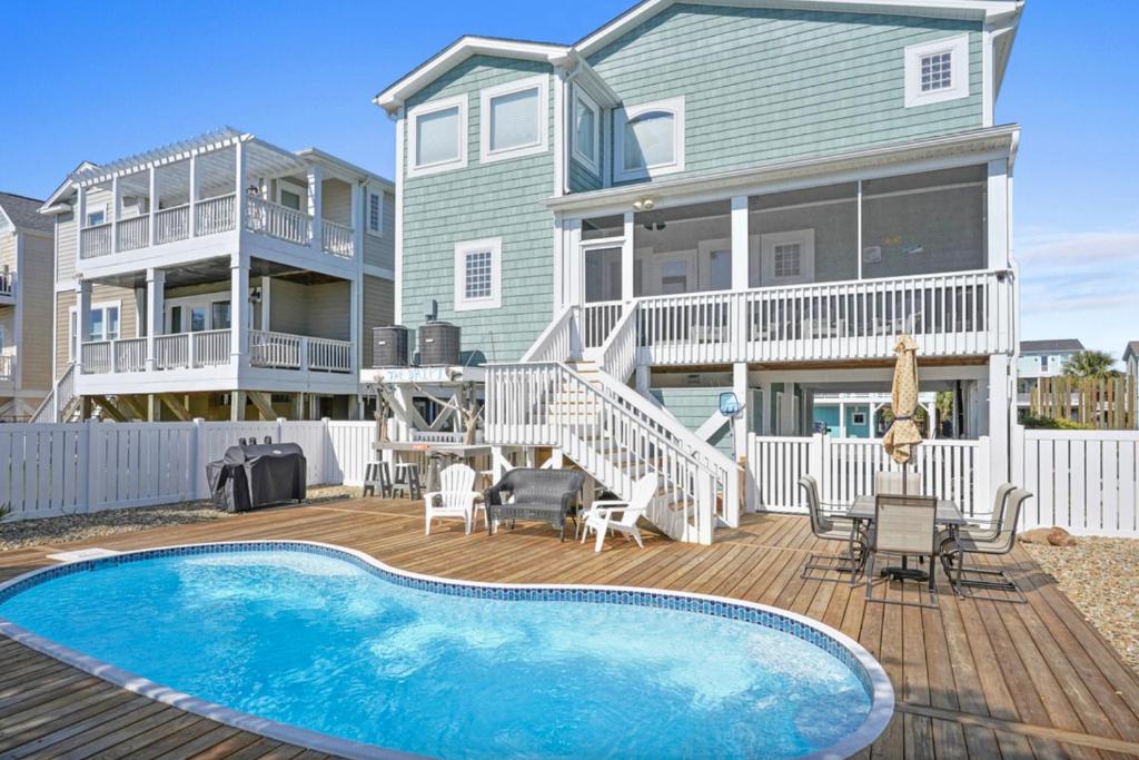 a house with a swimming pool in front of a house at Marsh Mellowed by the Sea Brunswick Vacation Rentals Privated heated pool and beach in Holden Beach