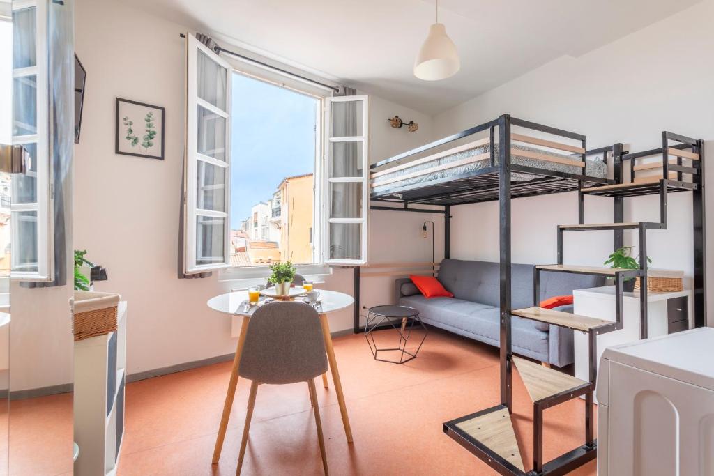 Cette chambre comprend une table et des lits superposés. dans l'établissement Studio calme et lumineux, à Aix-en-Provence