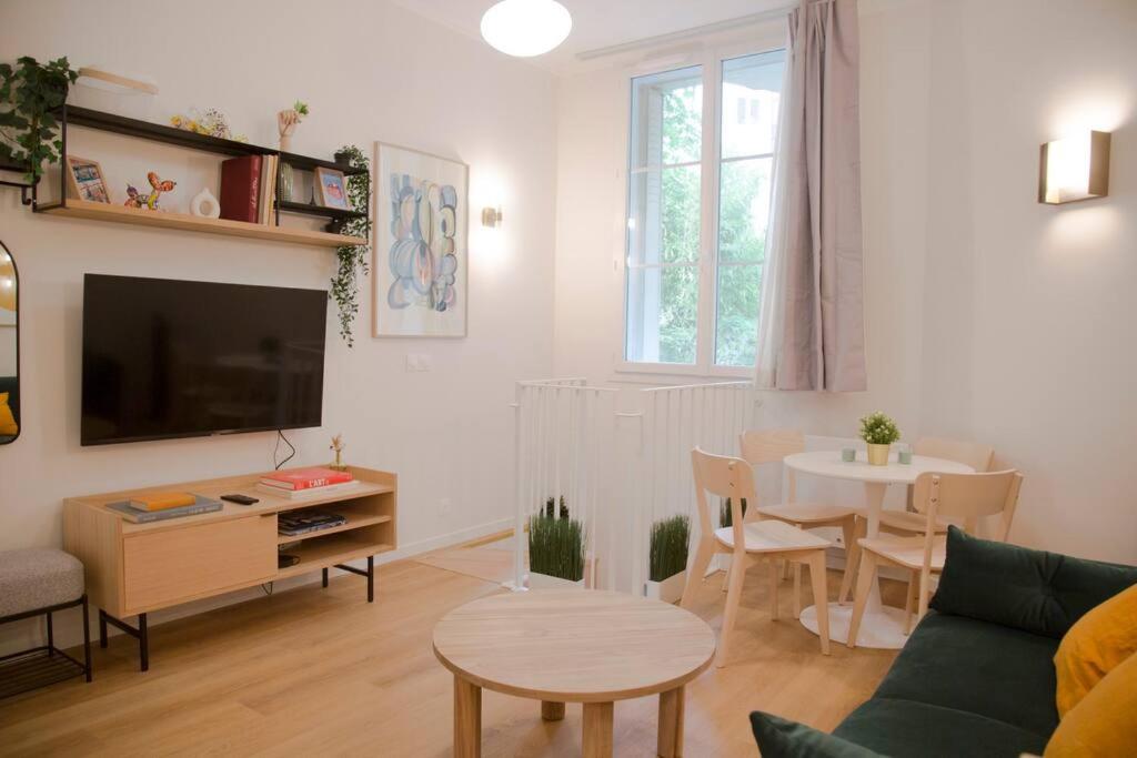 un salon avec un canapé et une table dans l'établissement Luxury Apt Raspail Denfert, à Paris