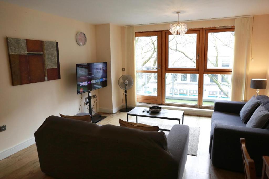 a living room with a couch and a tv at Stunning 2-Bed Apartment in Birmingham in Birmingham