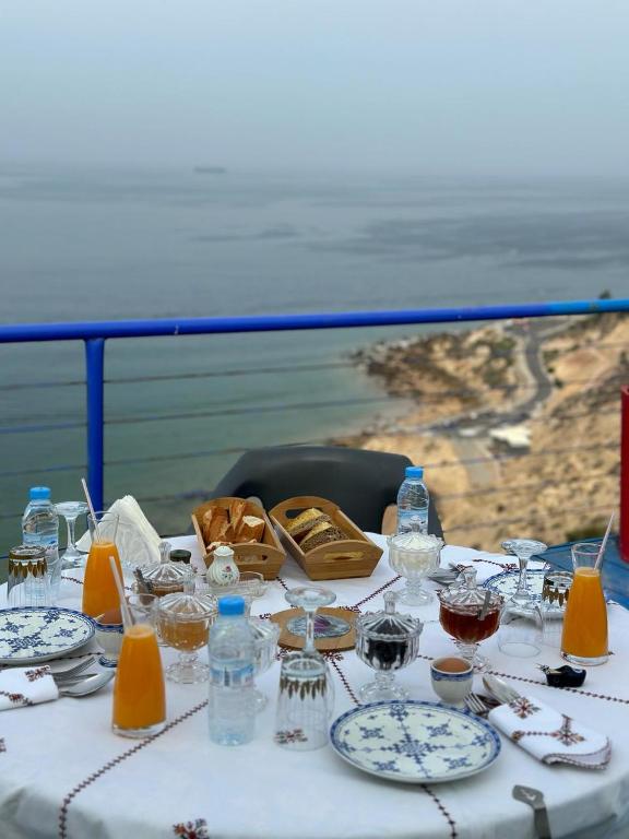 a table with plates and bottles and glasses on it at Riad Ras Lafaa in Safi