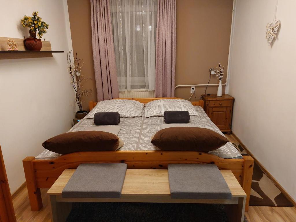 - une chambre avec un lit en bois et 2 oreillers dans l'établissement Kata Vendégház, à Sátoraljaújhely