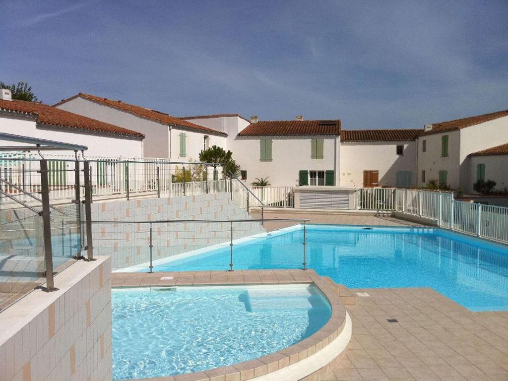 uma grande piscina em frente a uma casa em Les Mouettes Appartement cosy avec piscine em Saint-Martin-de-Ré