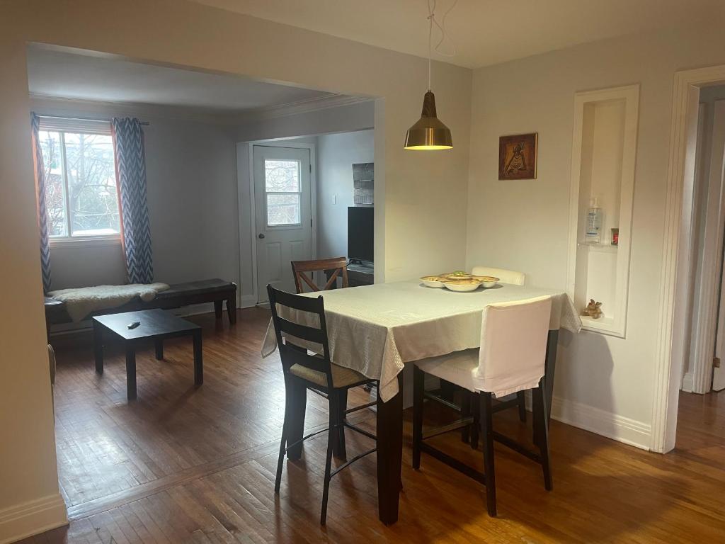 a dining room and living room with a table and chairs at Appartement près du Métro in Laval