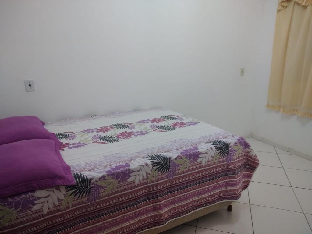 Una cama con una manta en una habitación en Casa Glenda, en Caparaó Velho