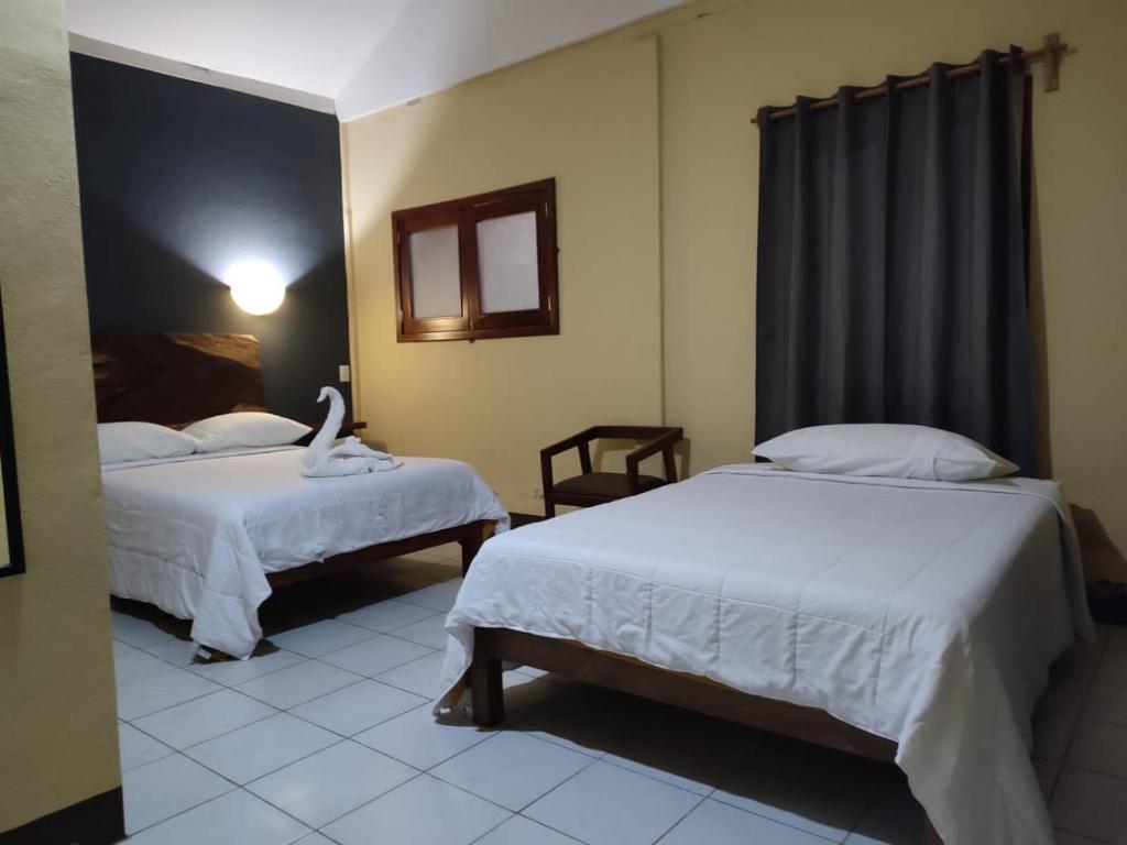 um quarto de hotel com duas camas e uma janela em Finca San Antonio em Pluma Hidalgo