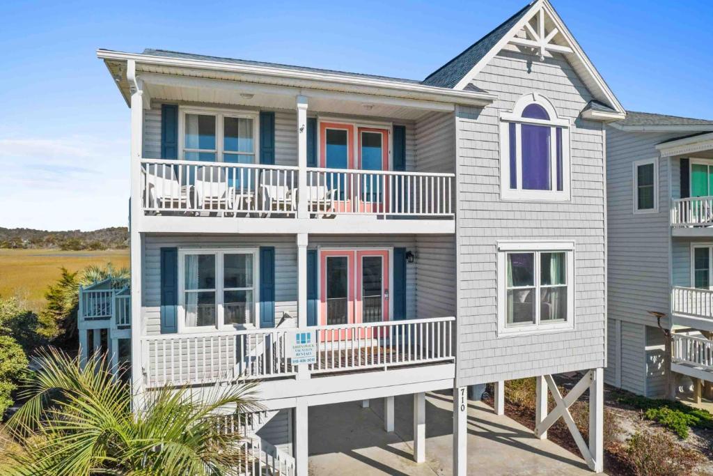a large house with a white and blue at Saltans of Swing Brunswick Vacation Rentals in Holden Beach