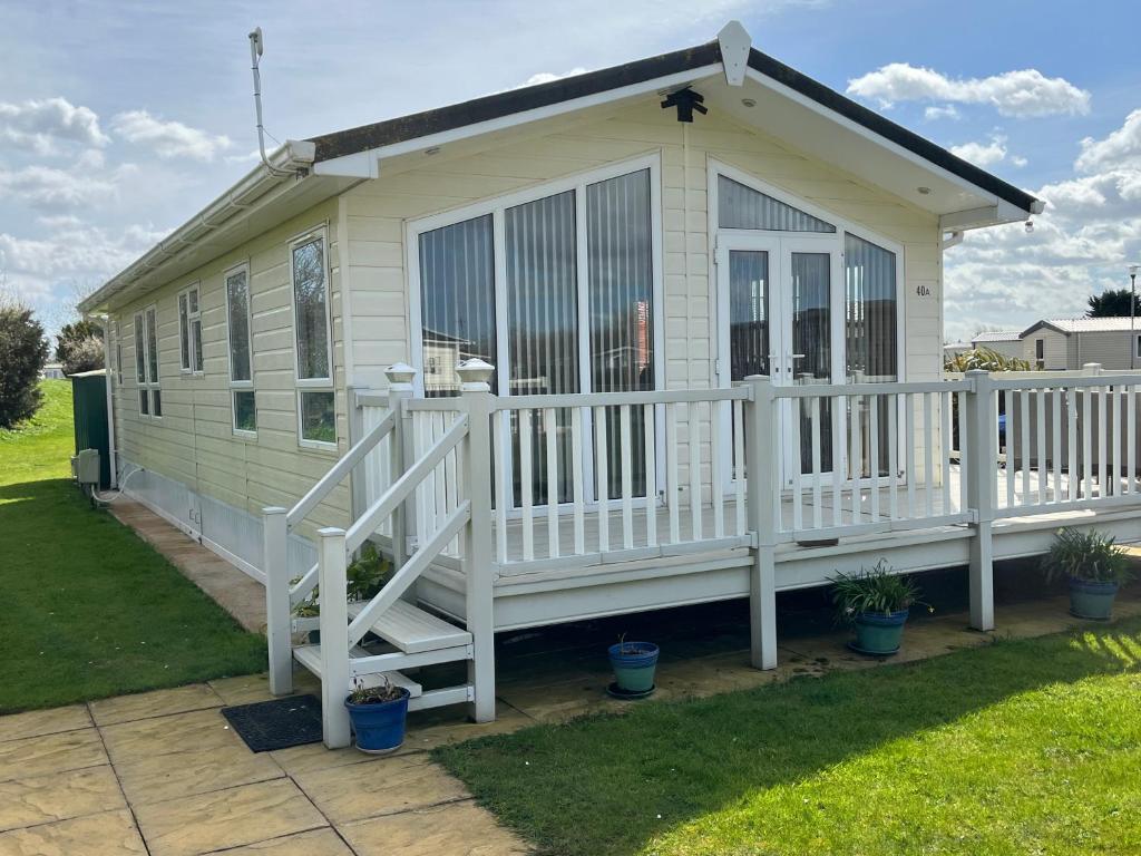 a tiny house with a porch and a deck at 40A Oak Village- 2 Bedroom Lodge on Grange Leisure Park in Mablethorpe
