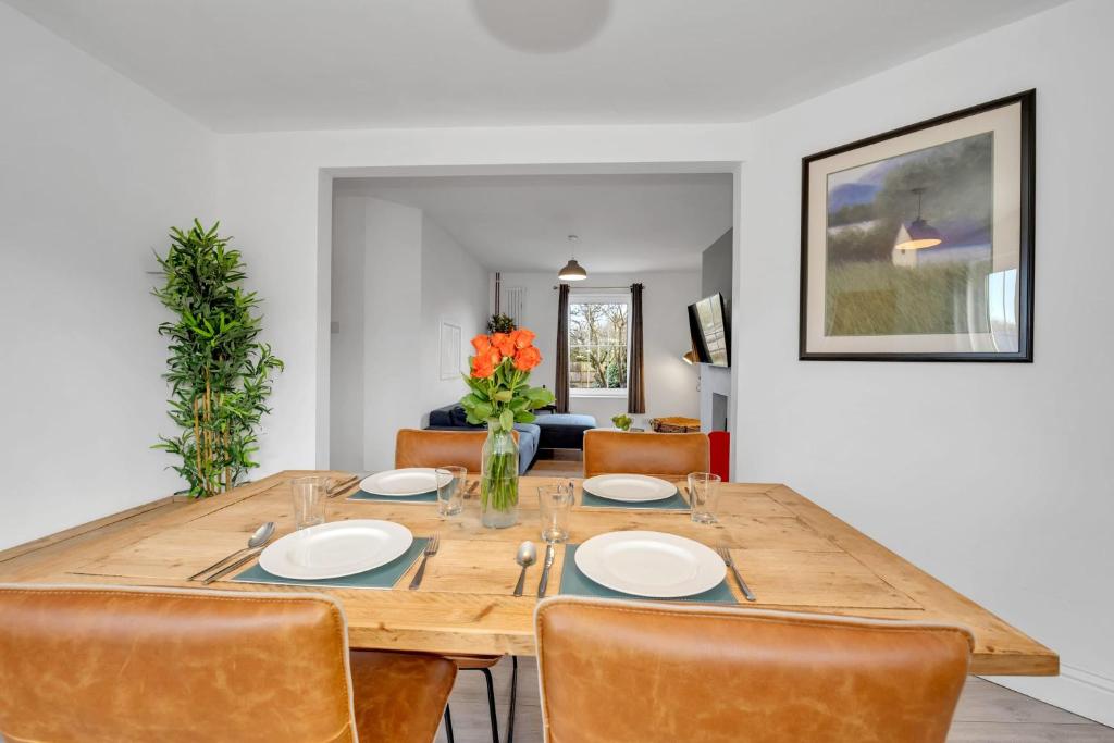 a dining room with a wooden table and chairs at End of Terrace 3 bedroom House with Garden in Newmarket